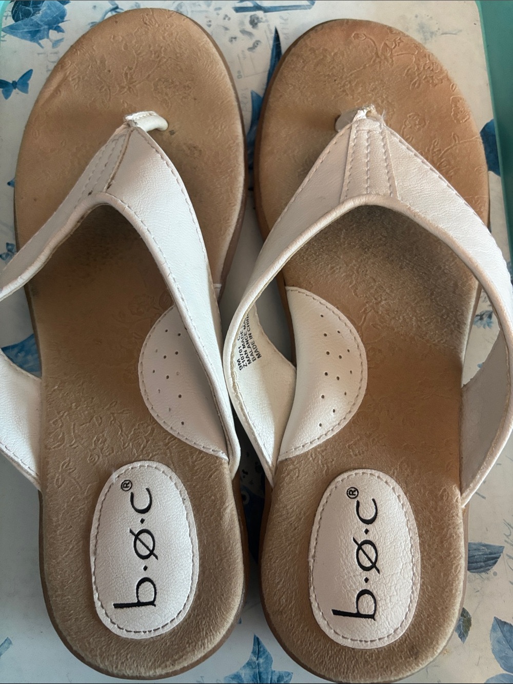 B.O.C. white thong sandals feature a cushioned, patterned tan footbed